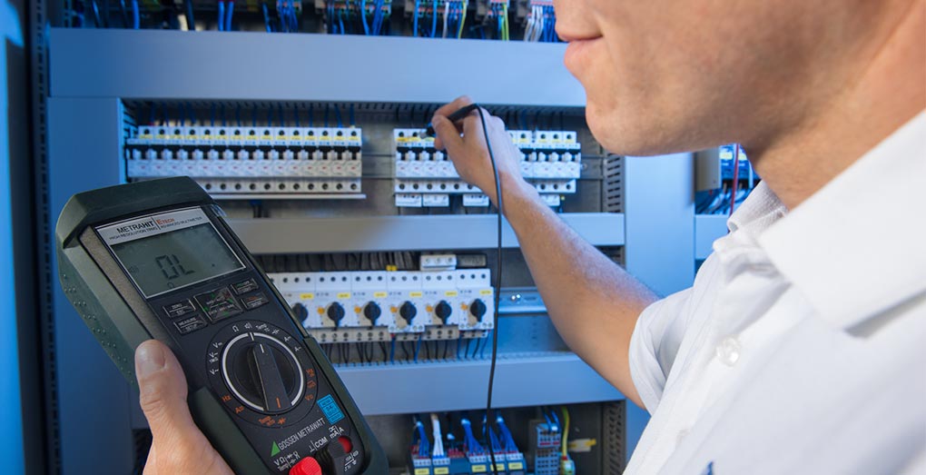 HPS Service - A worker with a meter on the control panel
