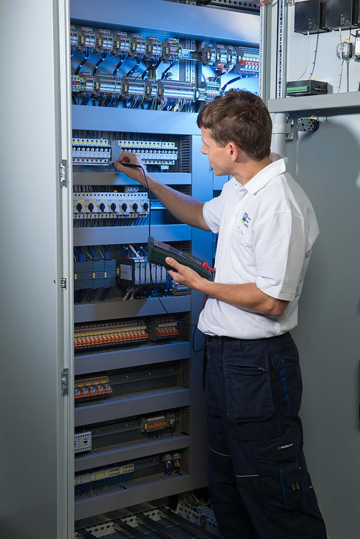 HPS - Employee carries out measurements in a control cabinet