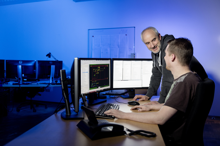 HPS - 2 Mitarbeiter beraten sich vor einer Computer Workstation